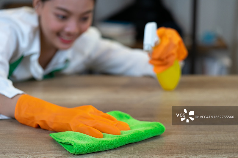 女人用海绵和清洁剂清洁家庭办公室，清洁概念，清洁桌子图片素材