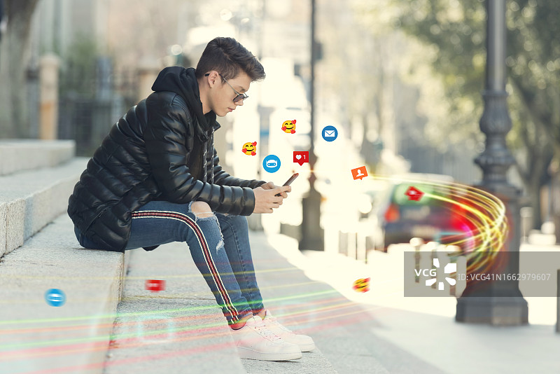 坐在楼梯上使用智能手机的年轻男人图片素材