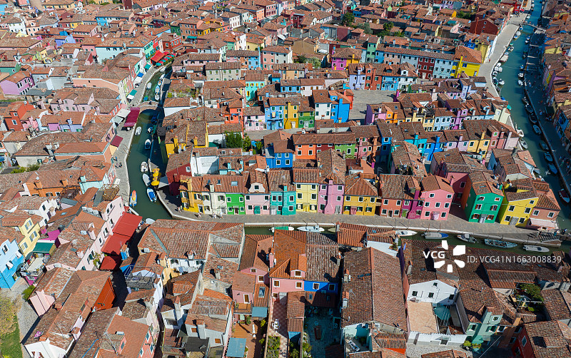 意大利威尼托地区布拉诺彩色房屋鸟瞰，运河沿岸停靠渔船，石桥横跨图片素材