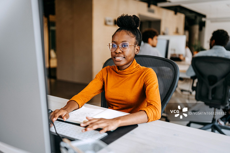 年轻女子在现代办公室工作图片素材