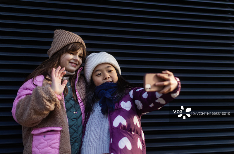寒冷冬日城市里自拍的可爱小女孩肖像图片素材