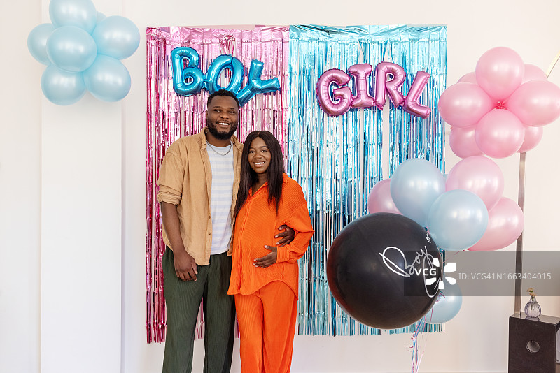 怀孕的夫妇在家里举办性别揭晓派对图片素材