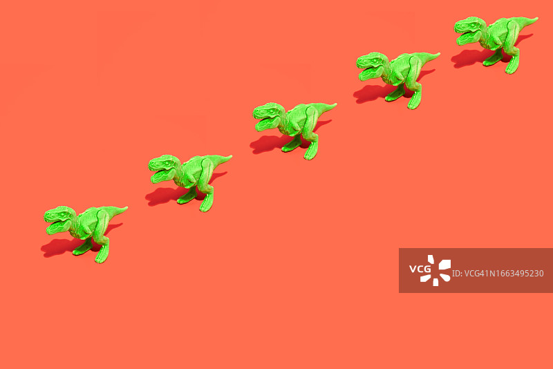 红色背景上的绿色塑料霸王龙图片素材