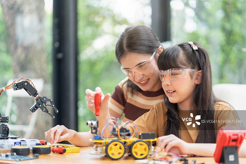 在家教育的女孩在家玩机器人项目图片素材