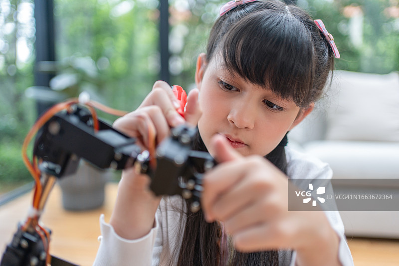 女学生为学校科学项目研究机器人手臂的电路板图片素材