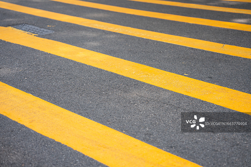 沥青路面上带有黄色条纹的行人横道线图片素材