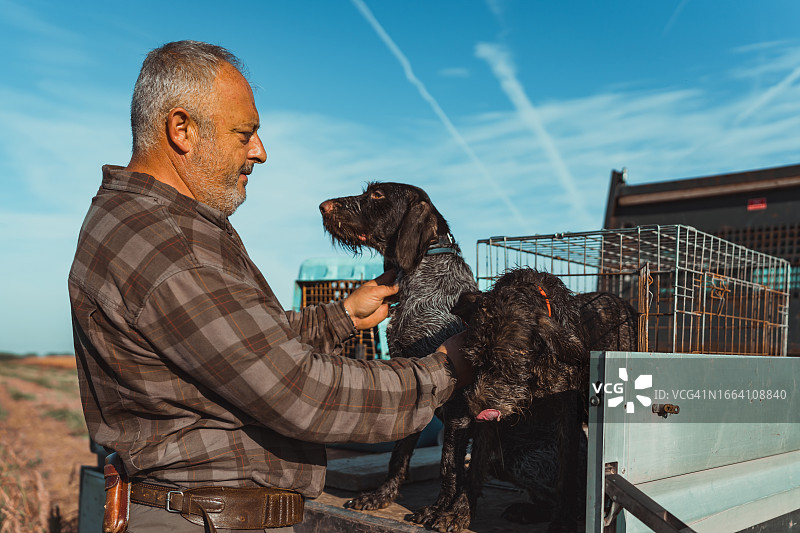 年长的白人男子照顾他的短毛指示犬图片素材