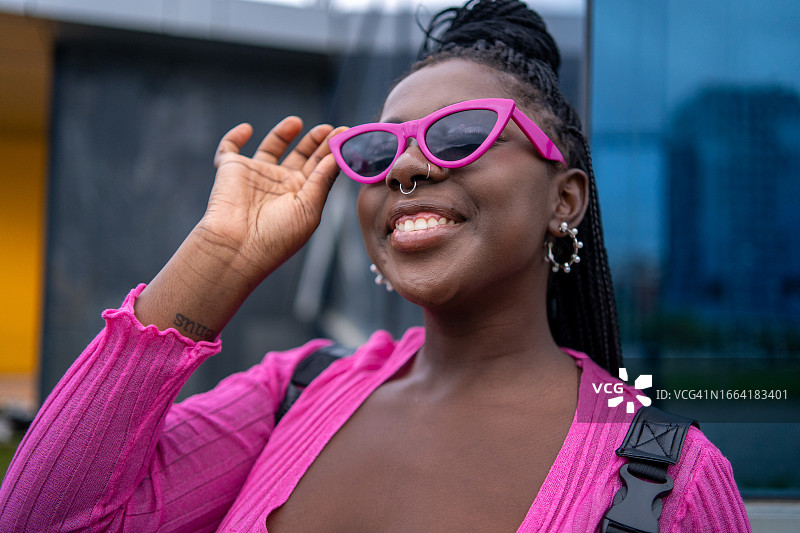 玩粉色太阳镜的快乐时尚非洲裔女人图片素材