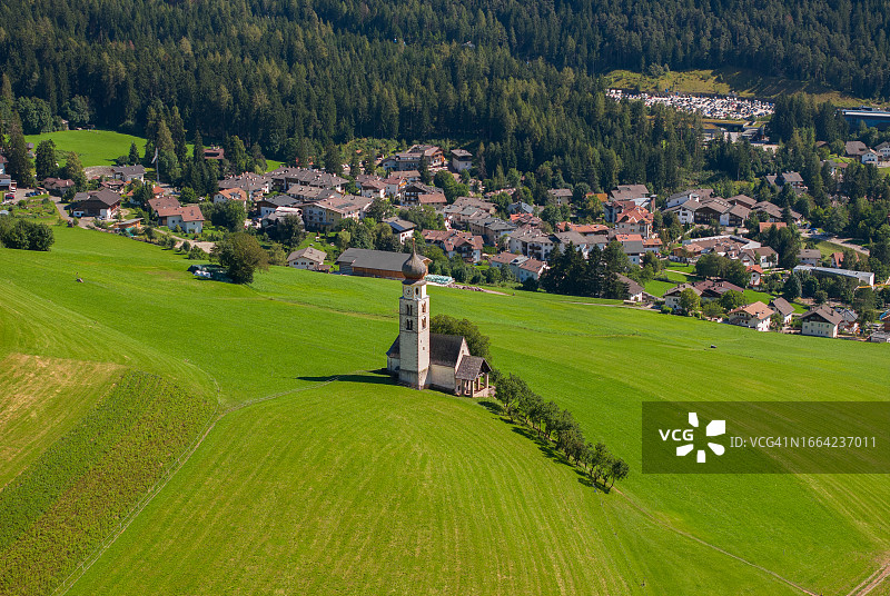 意大利阿尔卑斯山的迷人自然风光：卡斯特尔鲁特阿尔卑斯草甸上的圣瓦伦丁教堂夏季美景。多洛米蒂山脉，阿尔卑斯山脉，博尔扎诺，南蒂罗尔，意大利，欧洲图片素材
