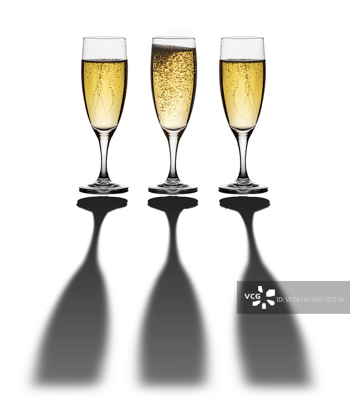 白色背景下带有长阴影的三杯香槟特写图片素材