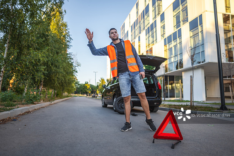 汽车抛锚后等待机械师的年轻男人图片素材