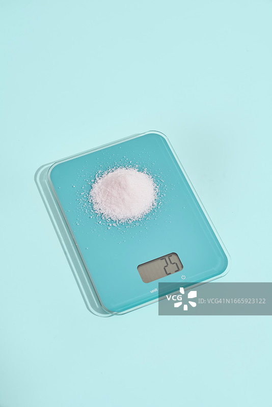 顶部有25克糖的绿色厨房秤图片素材