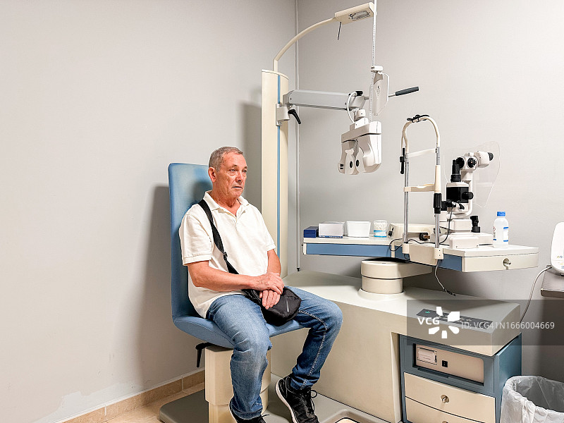 坐在眼科医生诊室等待视力检查的年长男人图片素材