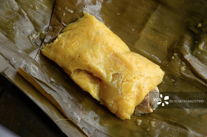 用鸡肉、米饭、猪肉、青豌豆和洋葱蒸制的黄色玉米粽图片素材