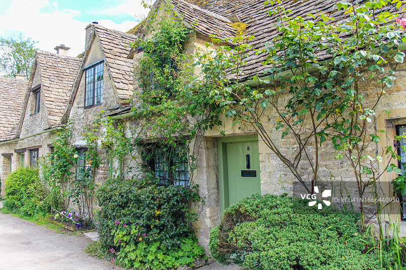 拜伯里村科茨沃尔德石材的古老乡村房屋，周围环绕着绿色图片素材