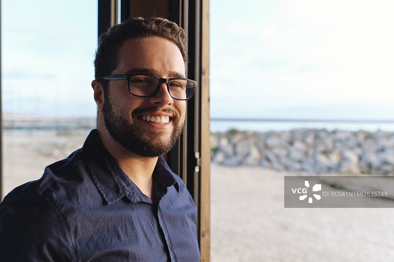 快乐的年轻工程师在咖啡馆戴着眼镜图片素材