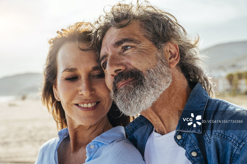 海滩边依偎在一起的老年夫妇图片素材