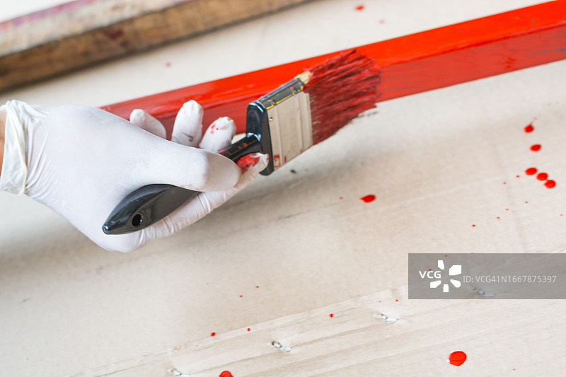 专注的中年木匠用保护剂涂抹木板图片素材