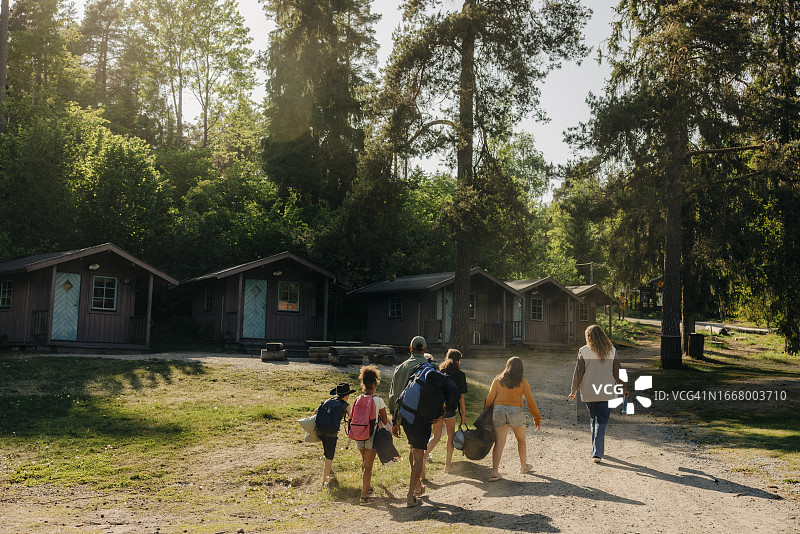 孩子们在夏令营与辅导员走向小屋图片素材