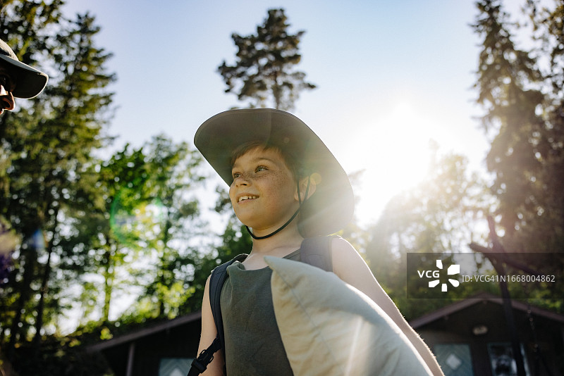 夏令营期间戴帽微笑男孩的仰视角度图片素材