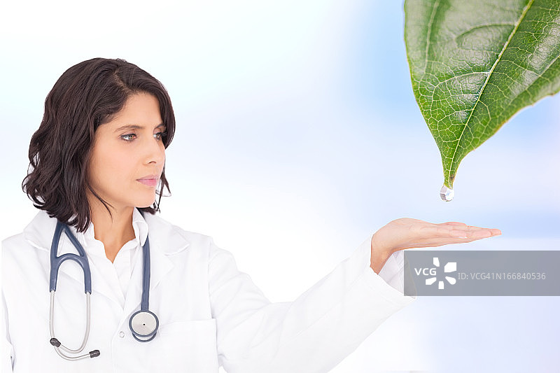 医生伸手去接从树叶上落下的露珠图片素材