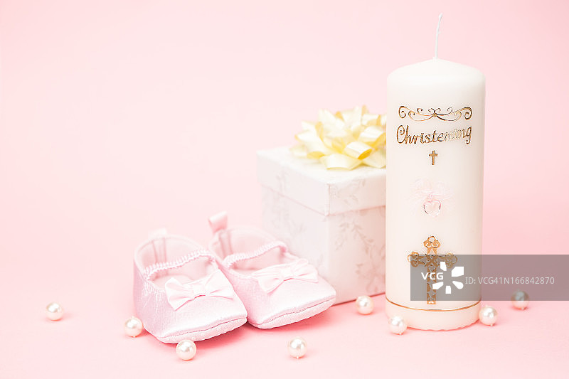 带有粉色婴儿短靴和礼品盒的洗礼蜡烛图片素材