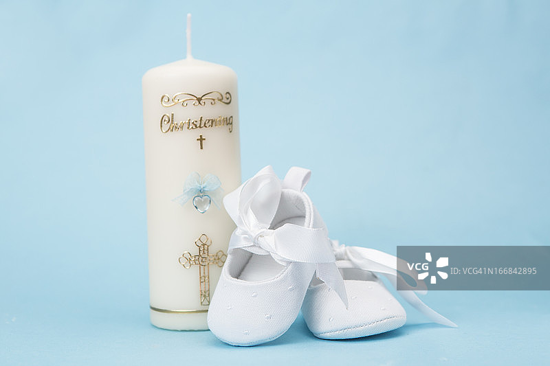 男婴洗礼蜡烛与白色婴儿鞋图片素材