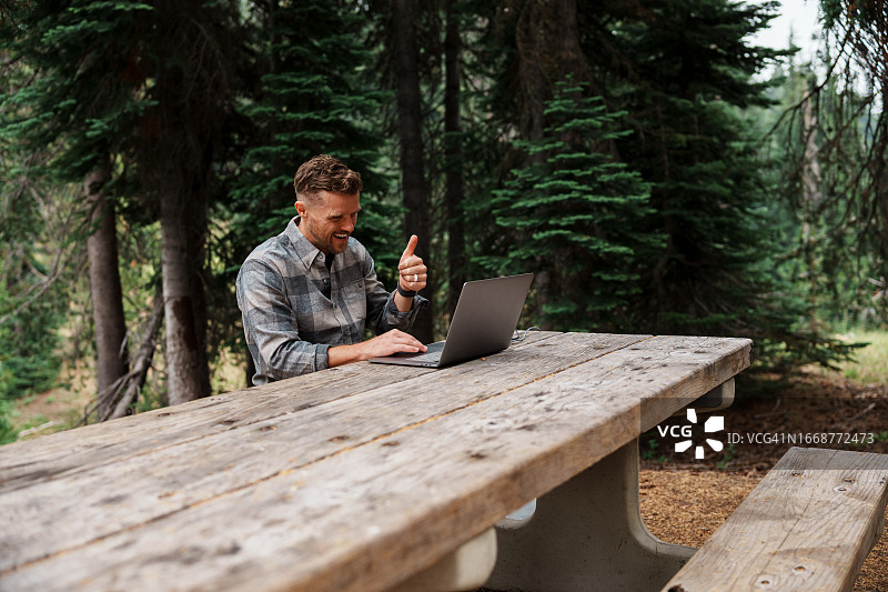 男人在露营旅行时使用笔记本电脑进行工作视频通话图片素材