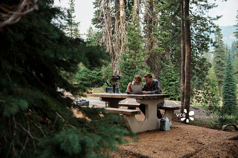 男人和家人在露营旅行时远程工作图片素材