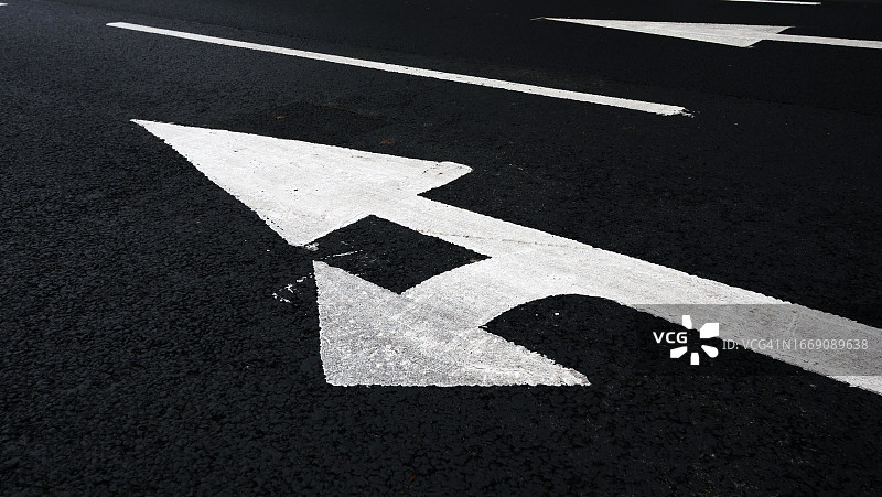 英国伦敦街道沥青路面上涂成白色并经过修饰的箭头图片素材