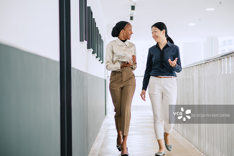 两位不同种族的女商人正在办公室交谈图片素材