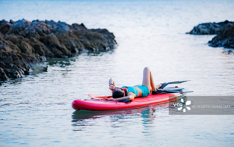 在泰国夏季假期的海上桨板上的亚洲运动女性图片素材
