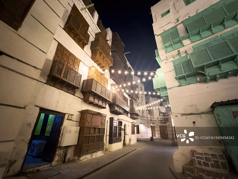 沙特阿拉伯吉达老城Al-Balad的灯泡装饰木制玛夏拉比亚老房子夜景图片素材