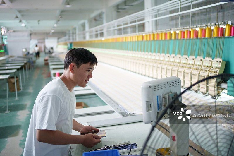 纺织厂工人在检查设备图片素材