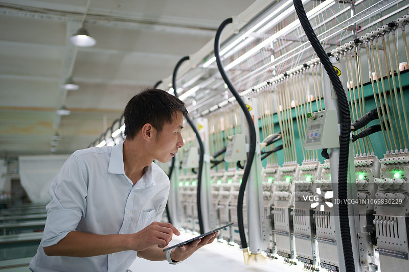 男性工人检查织布机图片素材