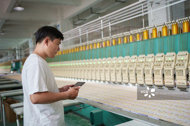 男性工人检查织布机图片素材