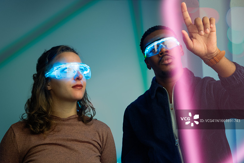戴着智能眼镜看电子屏幕的两人图片素材