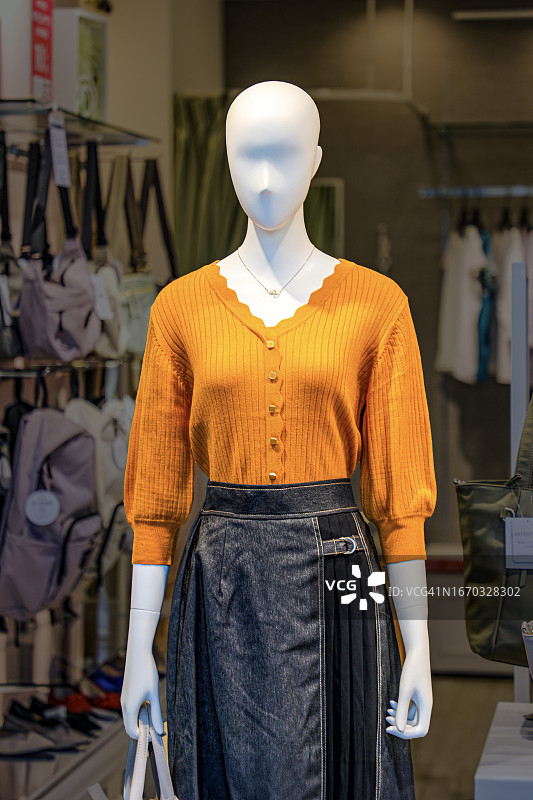 在已关闭的服装店橱窗中，像人体模型的女人图片素材