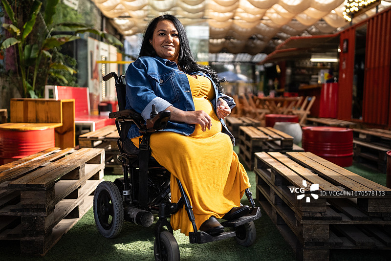 坐在酒吧或餐厅轮椅上的中年妇女肖像图片素材