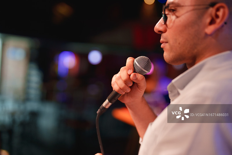 演讲者在舞台上用麦克风向观众做演示图片素材