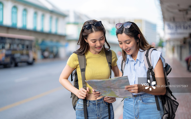 亚洲女性和朋友在度假期间享受城市观光图片素材