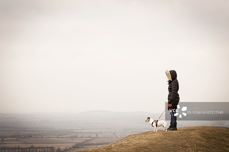 穿冬装的年轻女人与杰克罗素梗犬图片素材