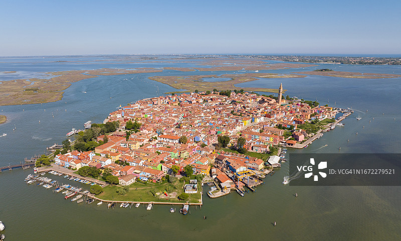 布拉诺岛彩色房屋沿堤岸排列，设有渔船和石桥，位于意大利威尼托大区威尼斯省图片素材