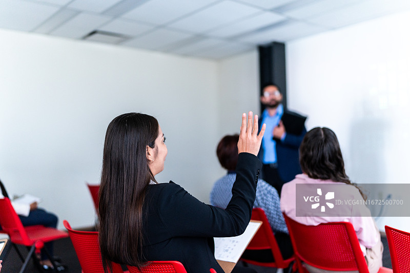 中年妇女在办公室会议上提问图片素材
