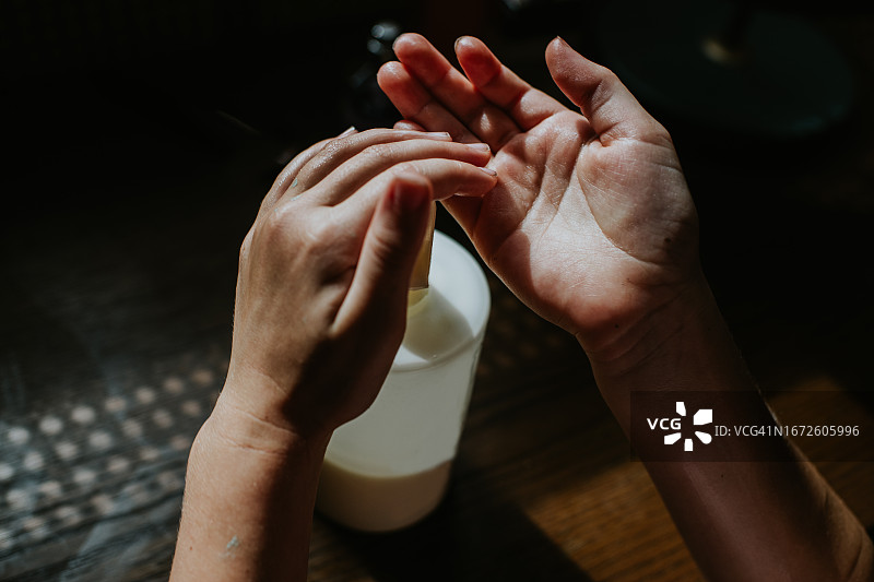 有人将液体香皂/润肤霜挤到手上图片素材