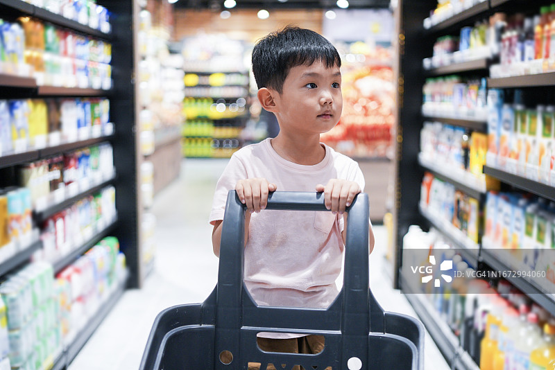 在超市购买零食的亚洲小男孩图片素材