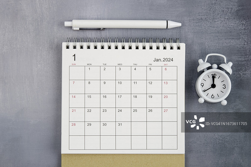 2024年台历：1月工作台上闹钟和白色笔日常工作生活计划图片素材