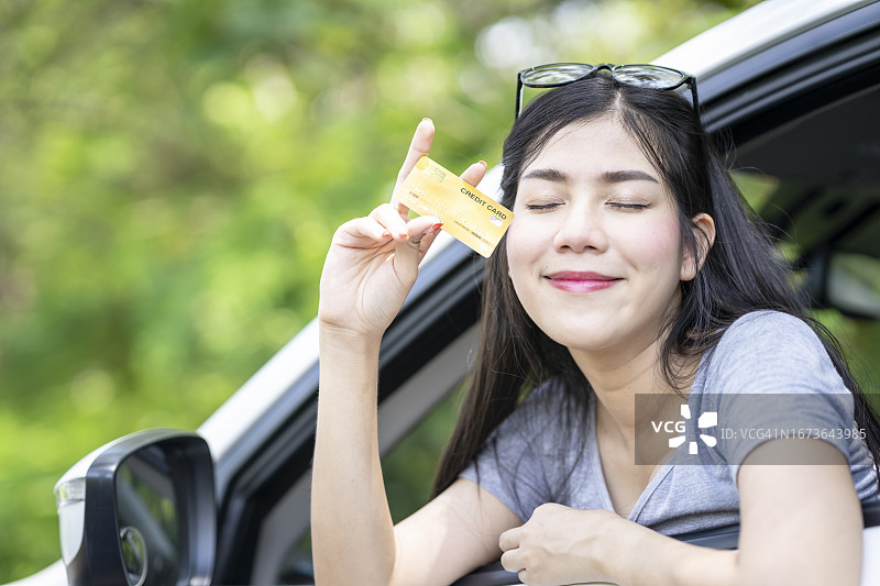 年轻的亚洲女性汽车旅行信用卡图片素材