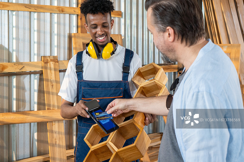 男子用信用卡支付木制家具订单图片素材