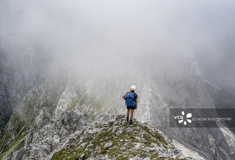 在德国巴伐利亚州加米施-帕滕基兴韦特施泰因山脉雾中恶劣天气下的登山者图片素材